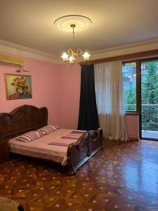a bedroom with a bed and a large window at Guesthouse Parnavaz Mepe in Batumi