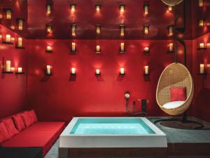 a hot tub in a room with red walls and candles at Chouchou Hotel in Paris