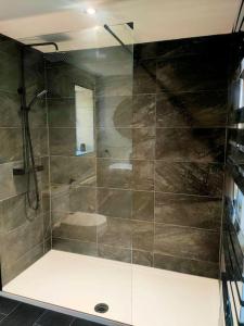 uma casa de banho com um chuveiro e uma porta de vidro em Liberty Lodge em Winsham
