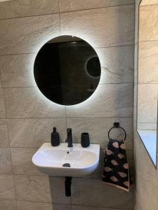 a bathroom with a sink and a mirror at Liberty Lodge in Winsham