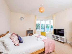 a bedroom with a large bed and a large window at Glas Mordros in St Ives