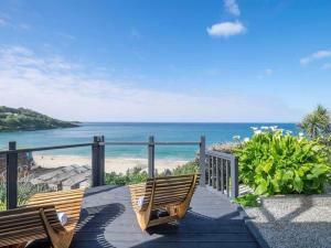 two benches sitting on a walkway to the beach at Glas Mordros in St Ives