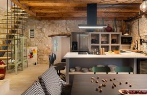 een keuken met stoelen en een bar met vogels op de vloer bij Dvor Pitve Villas in Jelsa