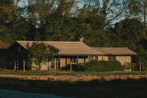 a house with a brown roof on a street at Pousada Natural Park in Imbituba