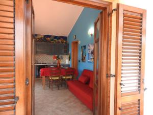 a living room with a red couch and a table at Casa Navarra in Santa Maria Navarrese