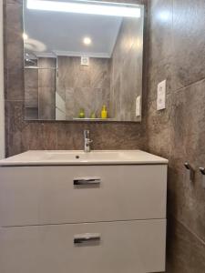 La salle de bains est pourvue d'un lavabo blanc et d'un miroir. dans l'établissement Dlalate, à Agadir