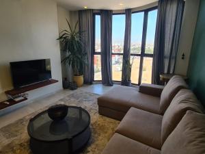 a living room with a couch and a large window at Dlalate in Agadir