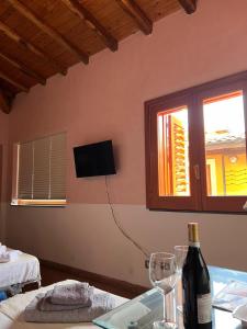 a room with a bottle of wine and a window at Il carrubo in Trecastagni