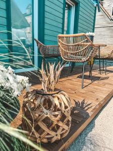 una terrazza in legno con due sedie e un vaso con una pianta di Ranna Apartment a Võru