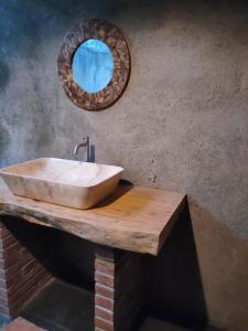 baño con lavabo y espejo en la pared en Java Turtle Lodge Meru Betiri, en Banyuwangi