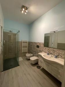 un bagno con due lavandini e una doccia e due servizi igienici di Arco di Levante alle Colonne a Bari