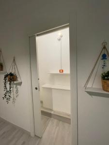 une porte menant à une pièce avec des étagères dans l'établissement Arco di Levante alle Colonne, à Bari