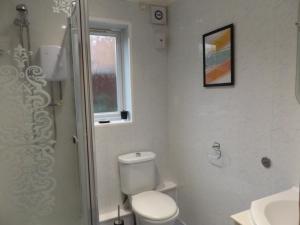 ein weißes Bad mit einem WC und einem Waschbecken in der Unterkunft Gainford House in Walsgrave on Sowe