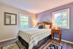 a bedroom with a bed and two windows at Nature's Edge in Asheville
