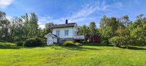 a small white house in a field of grass at Cabin magic on Senja, atmosphere like a fairytale in Botnhamn