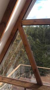 a window in a cabin with a view of the forest at Cabaña Bosque Tunquen in Valparaíso +20 photos