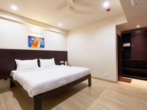 a bedroom with a large bed in a room at Hotel Tulsi-100 Feet From Ambabai Temple, Kolhapur in Kolhapur