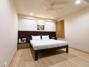 a bedroom with a bed in a room with a ceiling at Hotel Tulsi-100 Feet From Ambabai Temple, Kolhapur in Kolhapur