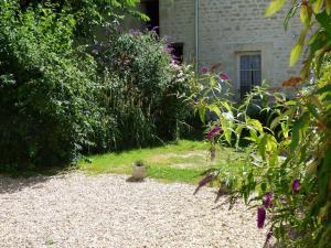 einen Garten mit einem Kieshof und einigen Pflanzen in der Unterkunft la cressonniere in Aulnay