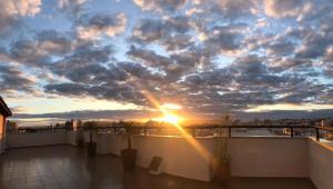 um pôr do sol no telhado de um edifício com nuvens em Hz Hotel em Patos de Minas
