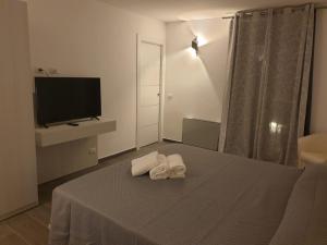 a bedroom with two towels on a bed with a television at CAVOUR ROOMS in Olbia