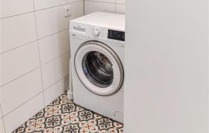 uma máquina de lavar roupa na casa de banho com piso em azulejo em Lovely Home In Vnersborg With Lake View em Venersburgo