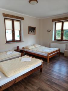a room with three beds in it with windows at Śnieżnicki Domek pokoje z prywatnymi łazienkami cisza i góry Stara Moraw in Stronie Śląskie