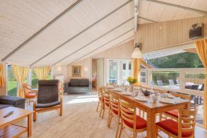 a dining room with a long table and chairs at Kranich Ferienhäuser mit Innenpool in Hohendorf