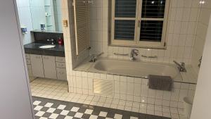 a bathroom with a tub and a sink at Ferienwohnung Rütiboda 8-10 Personen in Davos