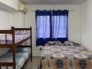 a bedroom with two bunk beds and a window at Apartamento Mar Vermelho in Balneário Camboriú