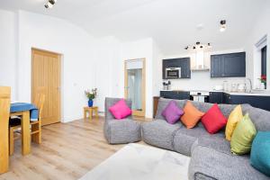 un soggiorno con divano grigio e cuscini colorati di Shiphorns luxury cabin with a hot tub a Eddleston