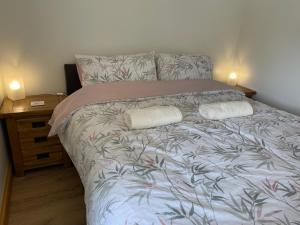 a bedroom with a bed with two pillows on it at Red Kite Barn in Ammanford