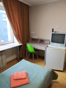 a bedroom with a bed and a desk with a laptop at Hotel Trias in Kyiv