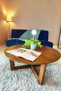 1519 Almas Suites SeaView Sunrise Netflix By STAY في نوساجايا: طاولة قهوة خشبية في غرفة معيشة مع أريكة زرقاء