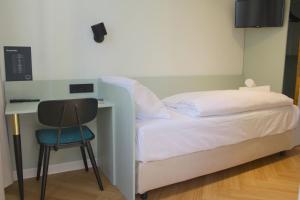 a bedroom with a bed and a desk and a chair at Autobahn Hotel Pfungstadt Ost in Pfungstadt
