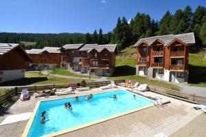 een groep mensen in een zwembad in een resort bij Les Chalets du Parc aux Etoiles - Cimes et Neige in Puy-Saint-Vincent