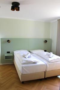 1 Schlafzimmer mit 2 Betten und weißer Bettwäsche in der Unterkunft Autobahn Hotel Pfungstadt Ost in Pfungstadt
