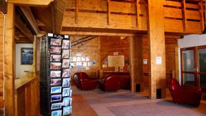 een grote kamer met stoelen en een bibliotheek met houten plafonds bij Les Chalets du Parc aux Etoiles - Cimes et Neige in Puy-Saint-Vincent