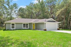 a house with a green lawn at Pet-friendly, Heated Pool, Close to Everything 3 Bedroom Home in Dunnellon