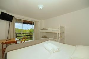 a bedroom with a bed and a desk and a window at pousada CASA 29 BÚZIOS in Búzios