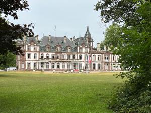 un grand bâtiment avec un champ vert en face dans l'établissement Park Line garden, à Strasbourg