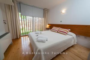ein Schlafzimmer mit einem großen Bett und einem großen Fenster in der Unterkunft A. Montesinho Turismo in Bragança
