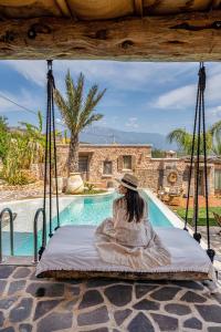 a woman sitting on a swing in front of a pool at Ada Dreams History - Adults Only in Fethiye