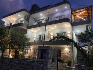 a large white building with lights on it at night at Villa Bodini Himare in Himare