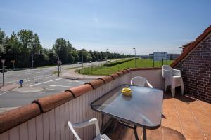 una mesa en un balcón con una taza de café en Gästehaus Olympia Wilhelmshaven - Moderne Einzelzimmer mit eigenem Bad für Monteure en Schortens