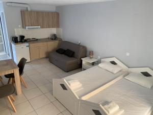 sypialnia z łóżkiem i kanapą oraz kuchnia w obiekcie Elia Beach Apartments Vrachos w mieście Loutsa
