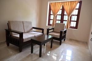 a living room with two chairs and a coffee table at Visao in Old Goa