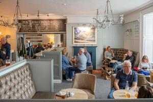 a group of people sitting in a restaurant at The Victoria Hotel in Bamburgh