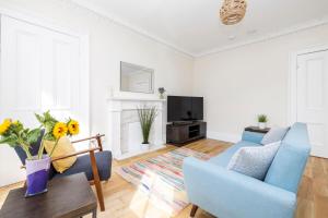 a living room with a blue couch and a tv at 2 bedroom apartment on Peebles High Street in Peebles