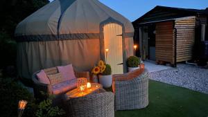 a backyard with wicker chairs and a gazebo at Thistlebank Yurt in Llangollen